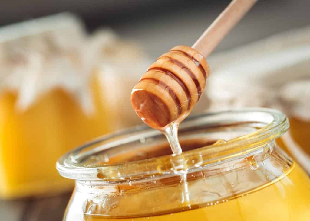 honey dripping into jar