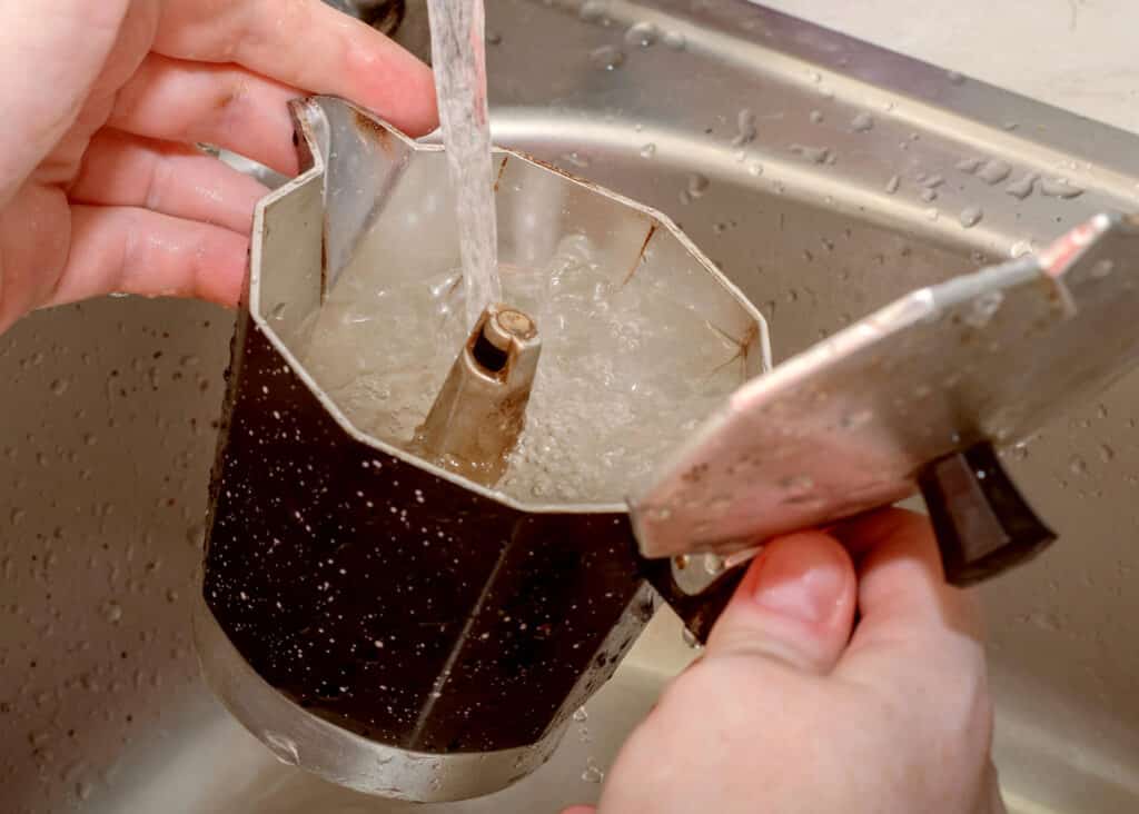 washing moka pot under running water