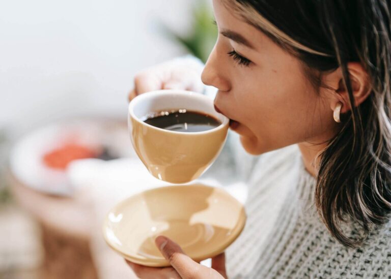 woman trying to determine aftertaste of coffee