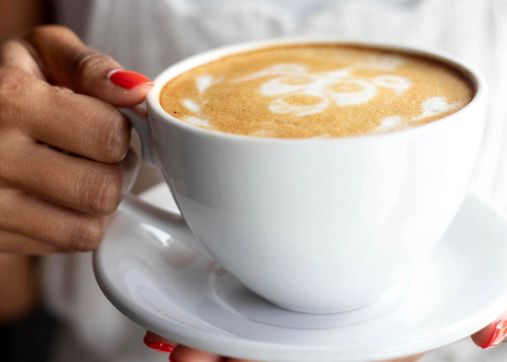 woman holding large latte