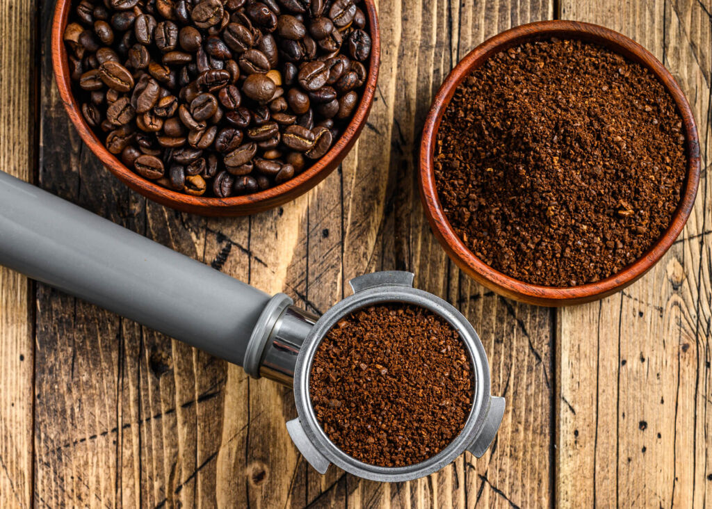 ground coffee in portafilter and coffee beans