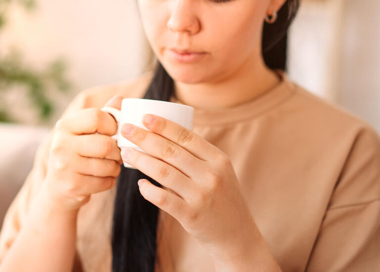 woman looking at coffee cup