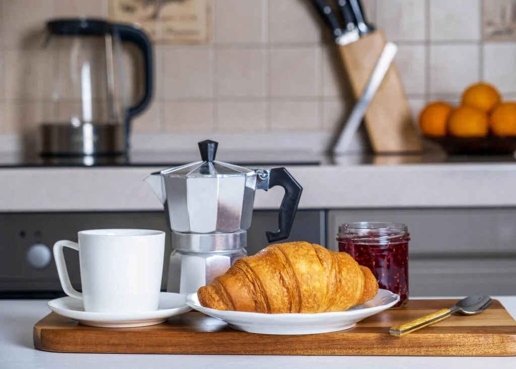 moka pot and croissant with jam