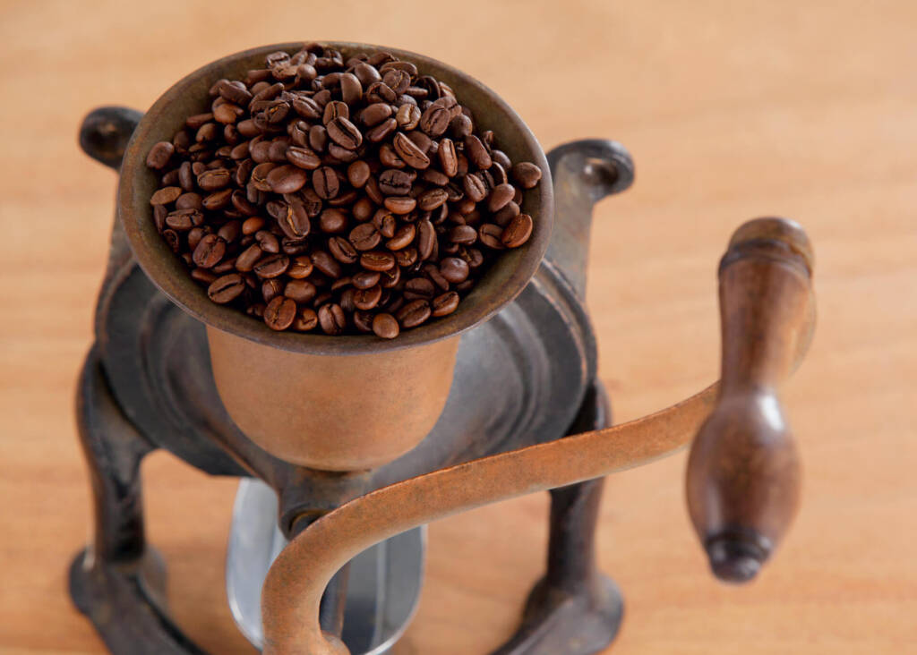 vintage coffee grinder filled with coffee beans
