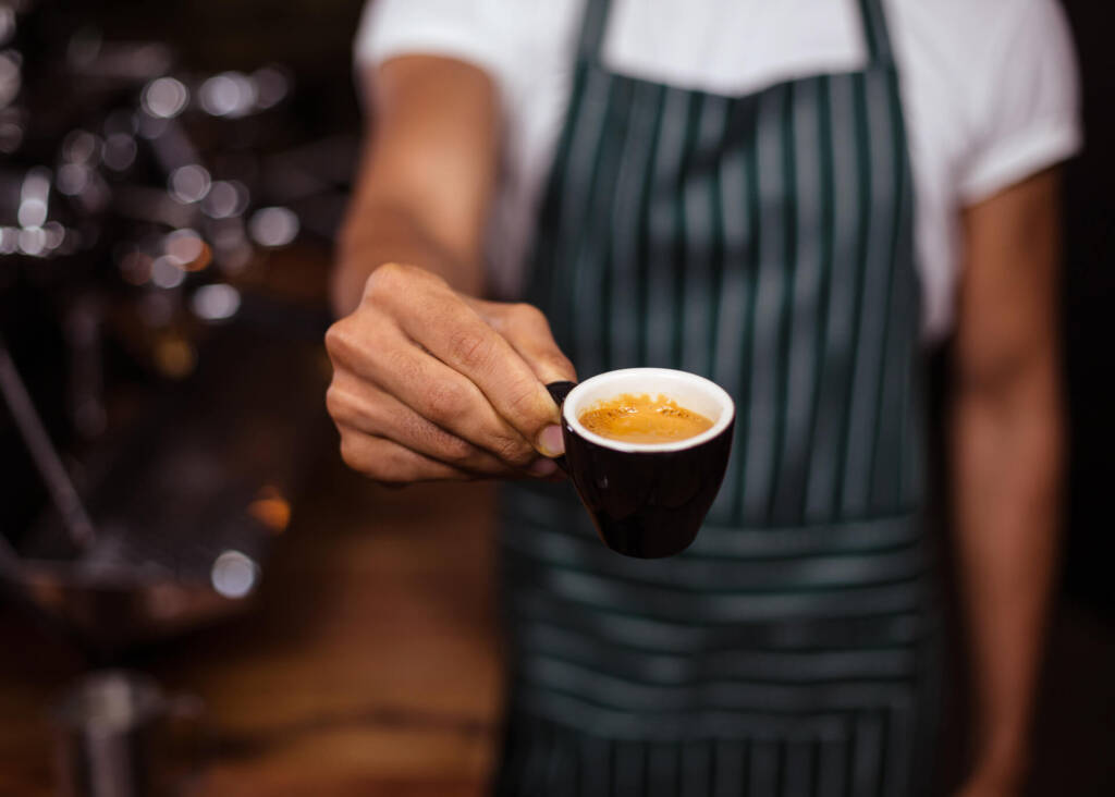 barista giving a cup of espresso